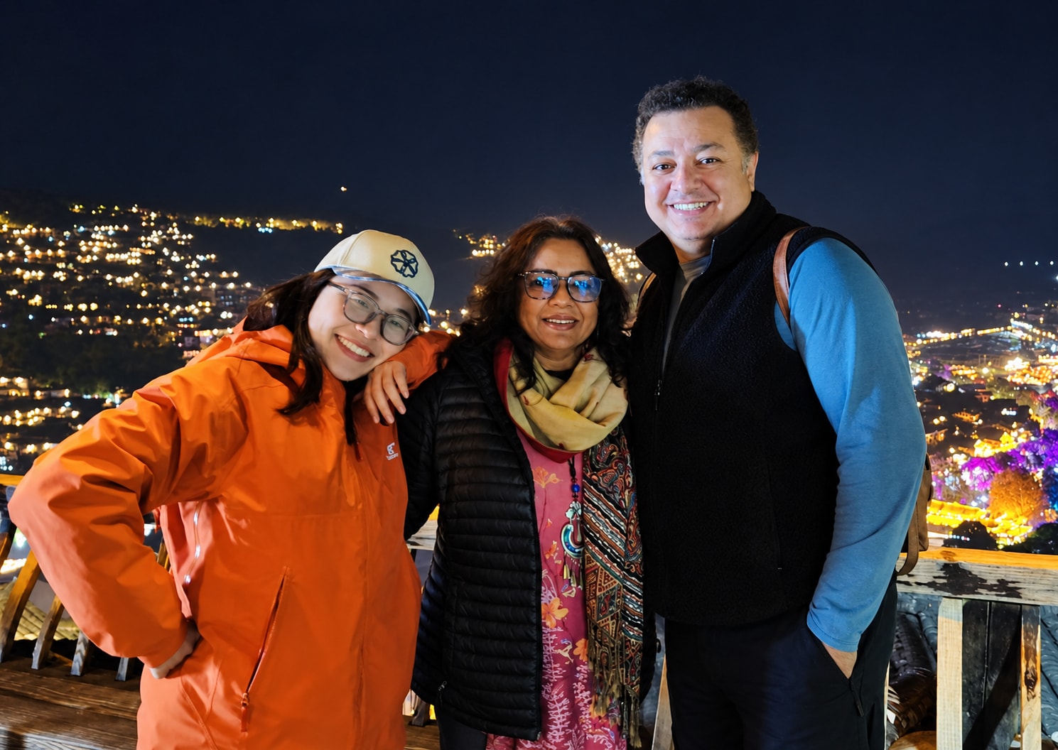 A guide and travellers in front of a city at night